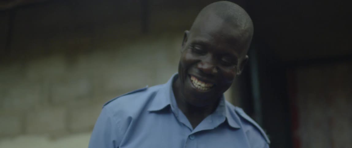 A man smiles while holding a picture