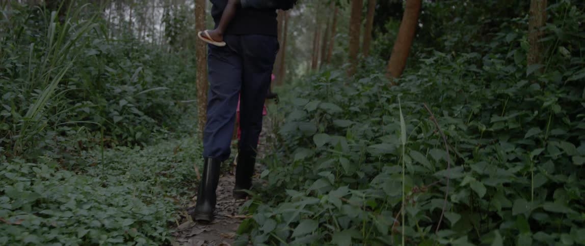 A man and two children walk in a forest