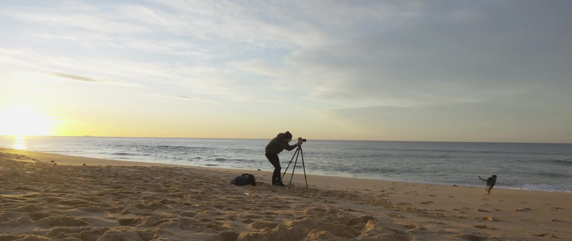 Man looking through his camera at the beach