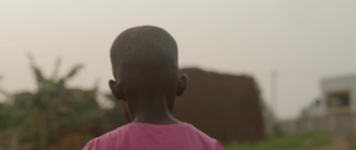 A child walks on a trail through the grass