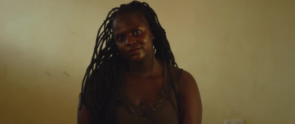 A woman with long braids looks straight ahead