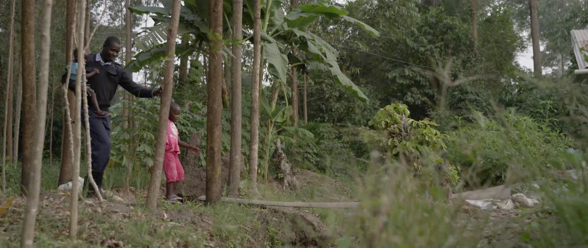 A father walks with two children in a forest