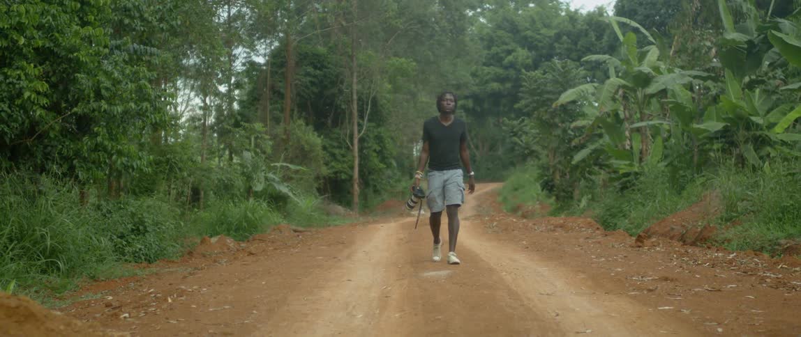 A man walks on a rural dirt road