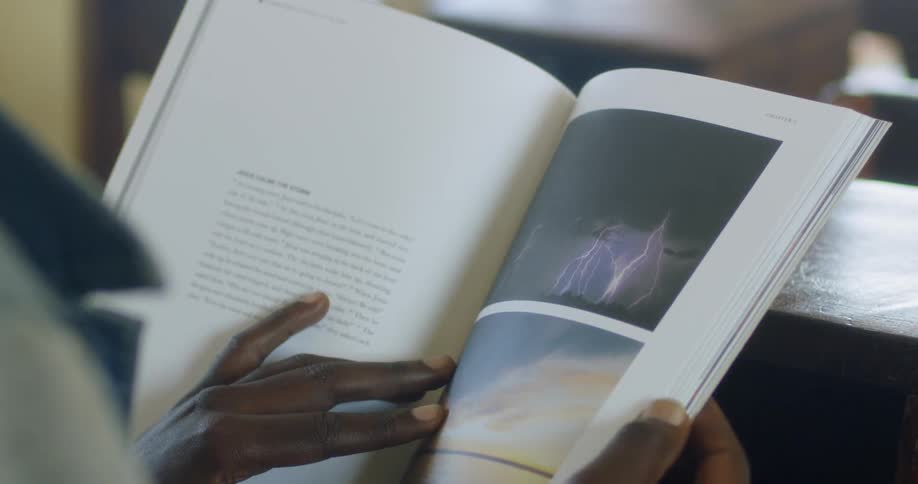 A person holds a book and turns the pages
