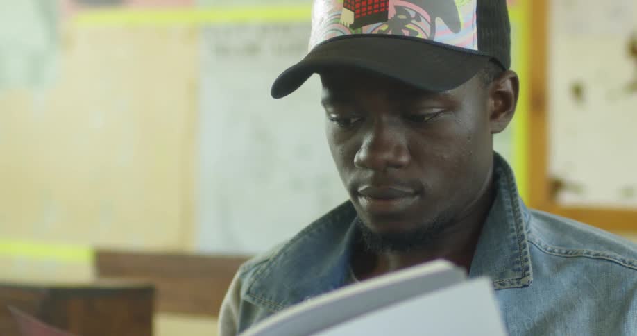 A man reads a book in a classroom