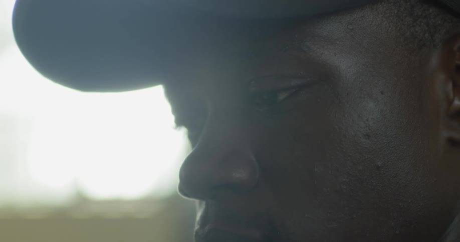 Man wearing a hat looks down outside