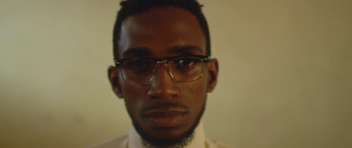 A man is wearing glasses and staring straight ahead