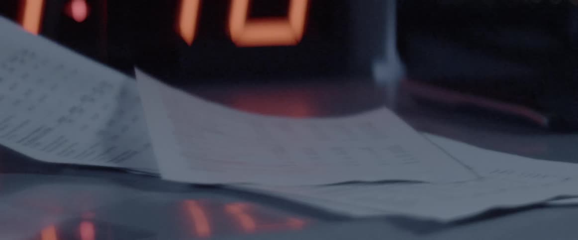 Paper documents and tables fall onto a desktop