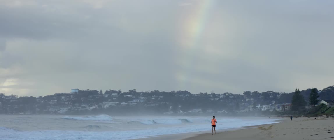 A woman is jogging on the beach