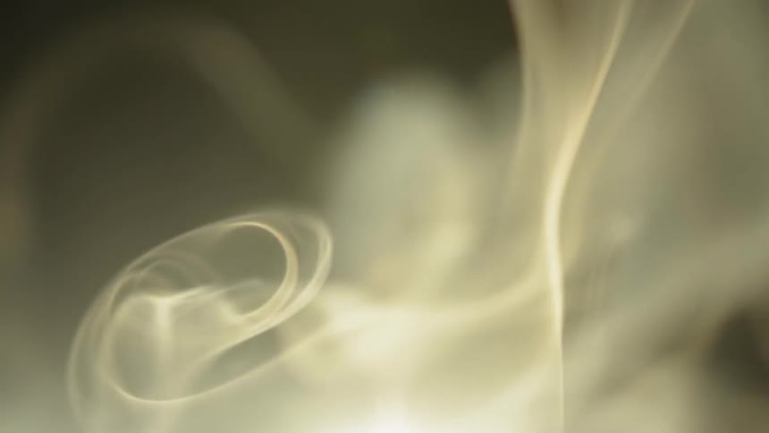 Smoke tendrils waft in bright light