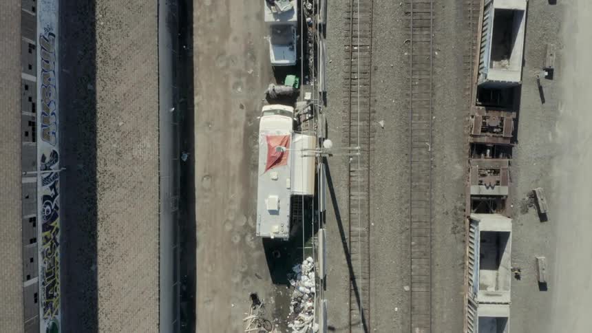 Rv's and campers parked along railroad tracks in a city