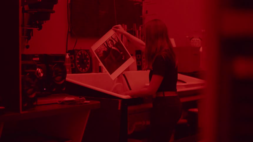 Woman develops film in a darkroom