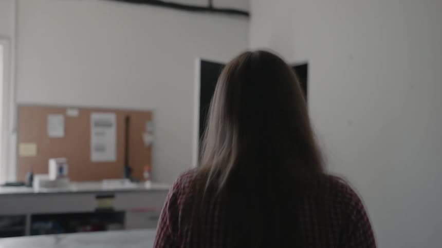 A woman walks towards a workbench