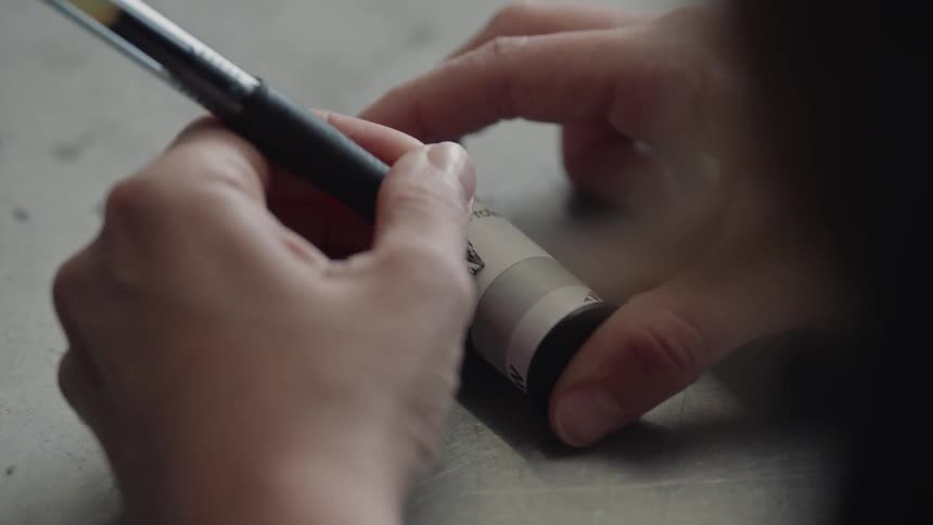 A woman writes on a roll of film