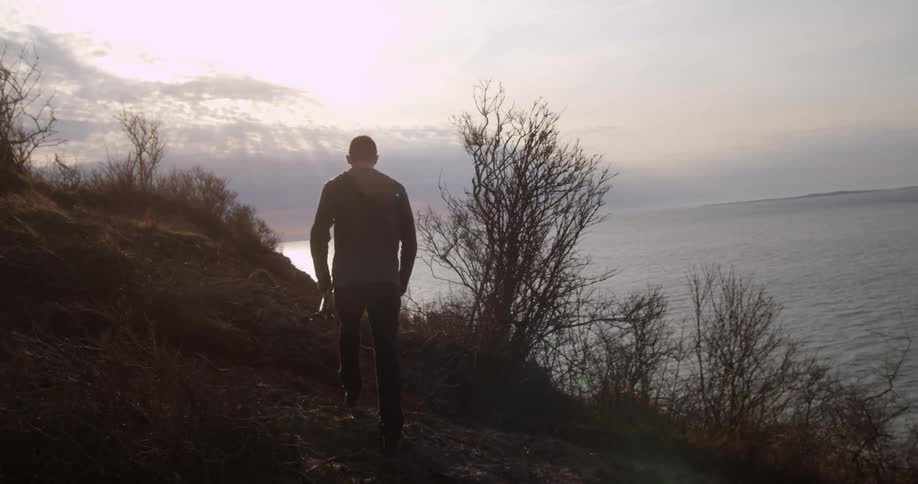 A man walks along a coastline