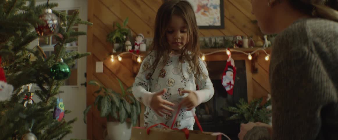 A young girl opens a christmas present