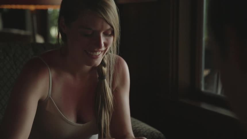 A smiling white woman puts objects in a wood tray