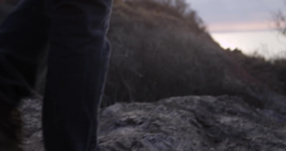 A man walks across rocks