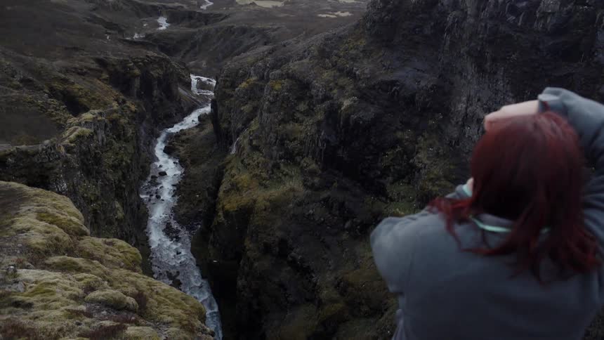 A woman takes photos of the birds flying over the stream
