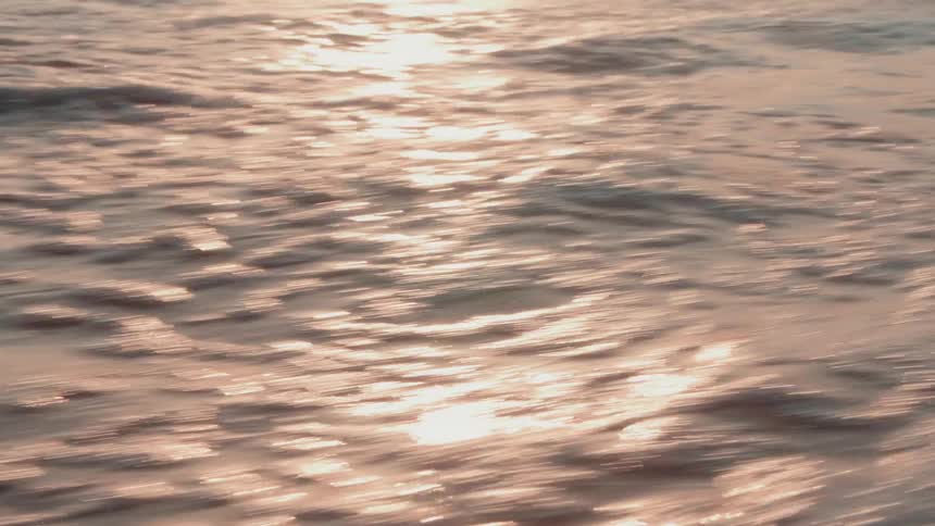 Water splashes and foams with the sun shining off it
