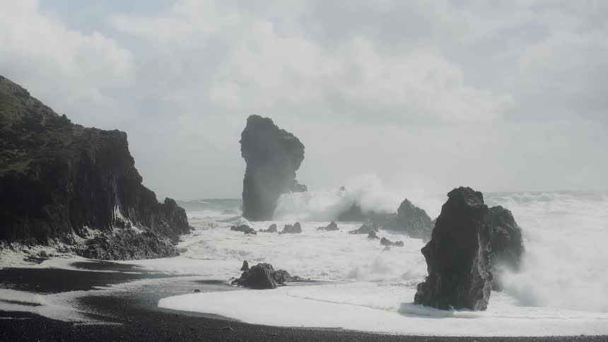Ocean waves crashing against large rocks on shore