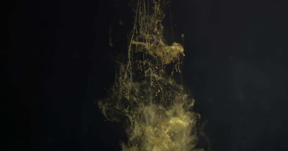 Gold clouds of dye float then sink in liquid