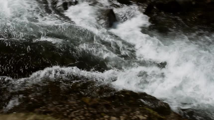Water flows rapidly down a stream