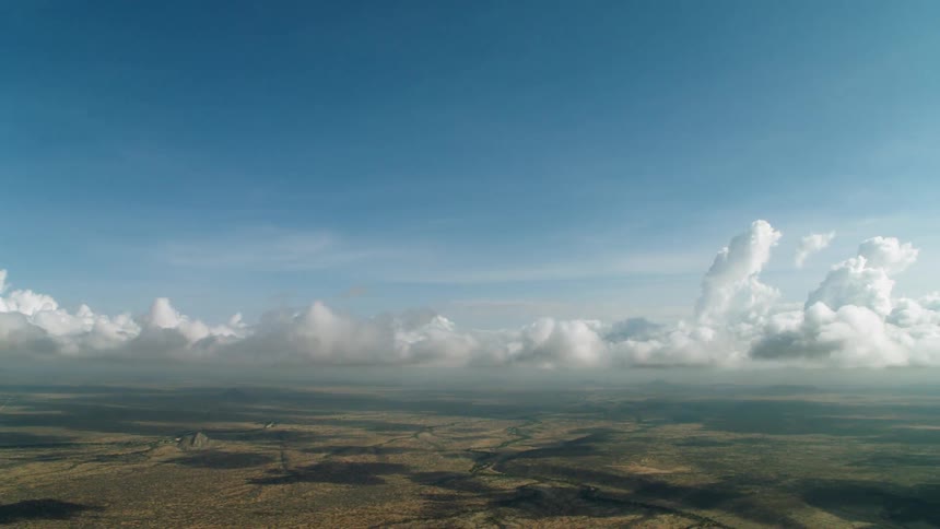 Flying through clouds above a valley