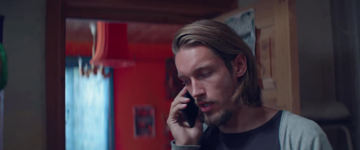 Close up shot of a serious guy looking down while using phone.