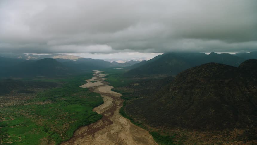 Dark clouds hang above the mountain valley
