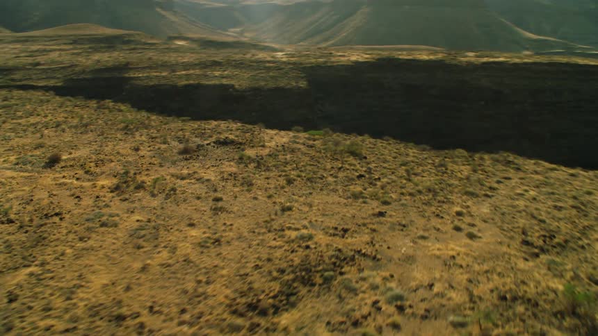 Brown hilly land with sun shining overhead