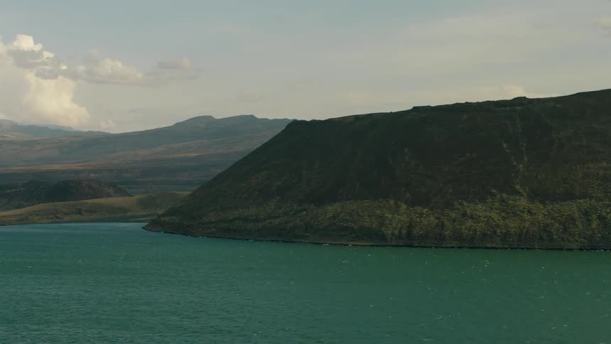 Blue water flows around a large crater