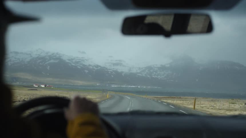 A man drives a car down the road