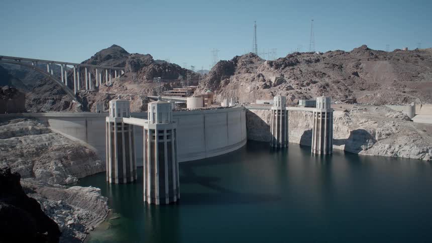 A dam barriers off water by the mountain range