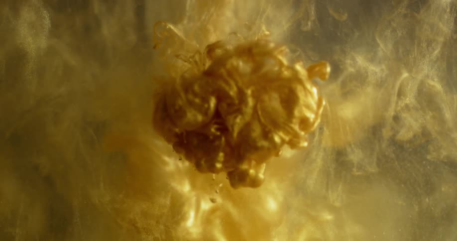 Yellow and gold dye clouds flow into water
