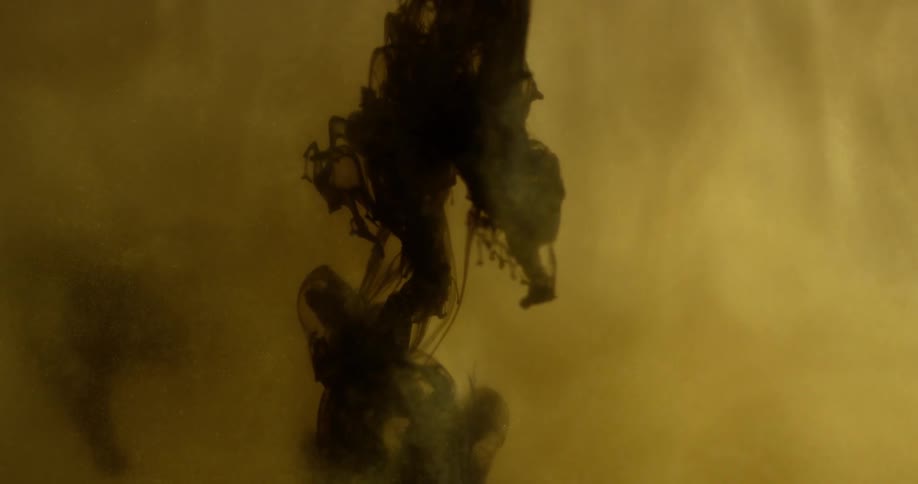 Dark ink falls into the white liquid