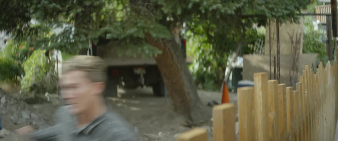 A young man runs frantically into a house