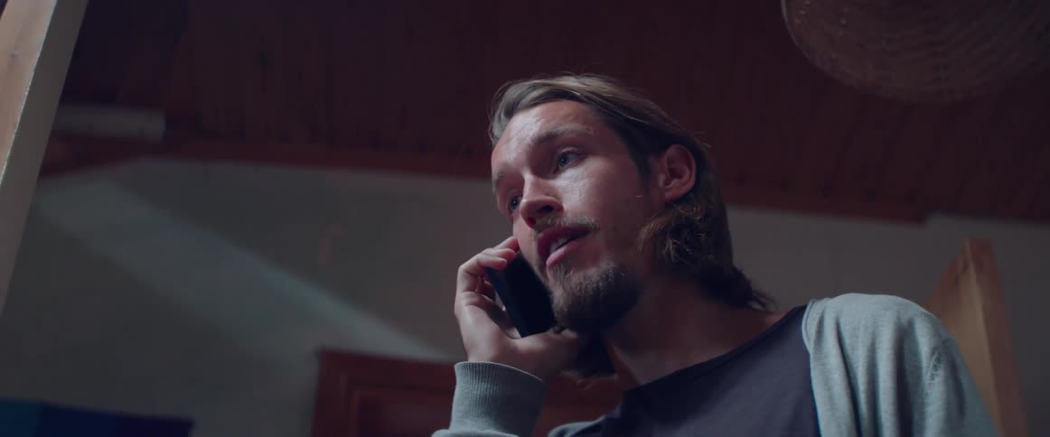 Close up shot of a bearded guy opening mouth to speak on phone.