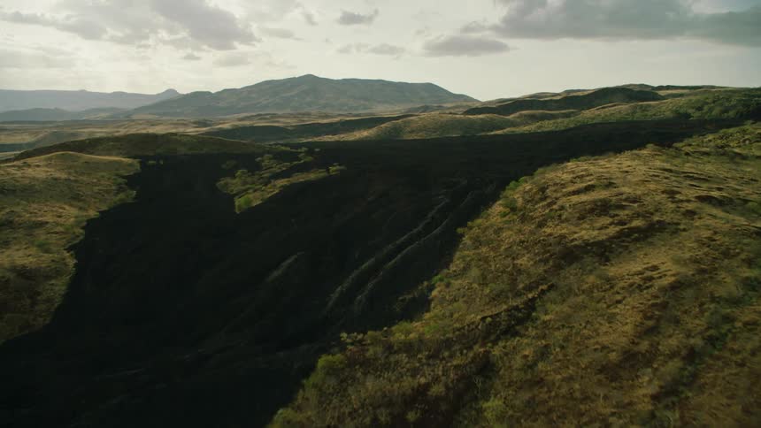 Grass and shrubs cover the hilly landscape