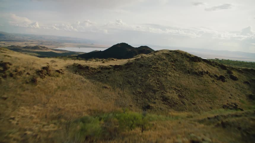 Grass and trees cover the hilly landscape