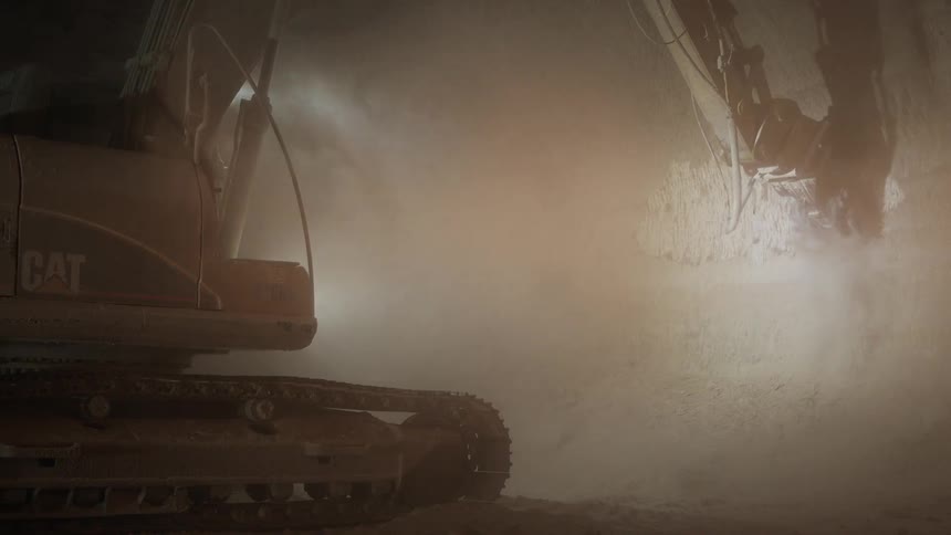A construction vehicle chisels through rock underground