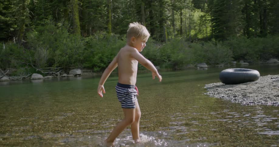 Boy plays in a shallow creek