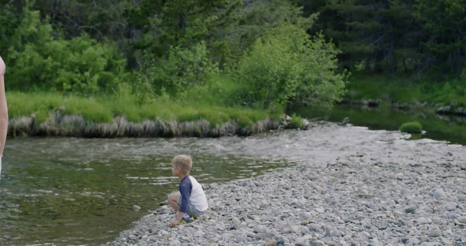 Child throws a rock into a stream