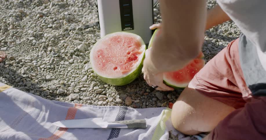 Some people are cracking open some watermelon to eat