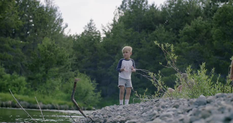Little boy throwing rocks in river