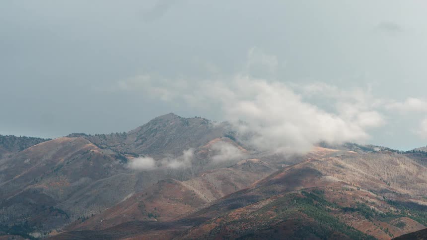 White clouds hang over hilltop peaks