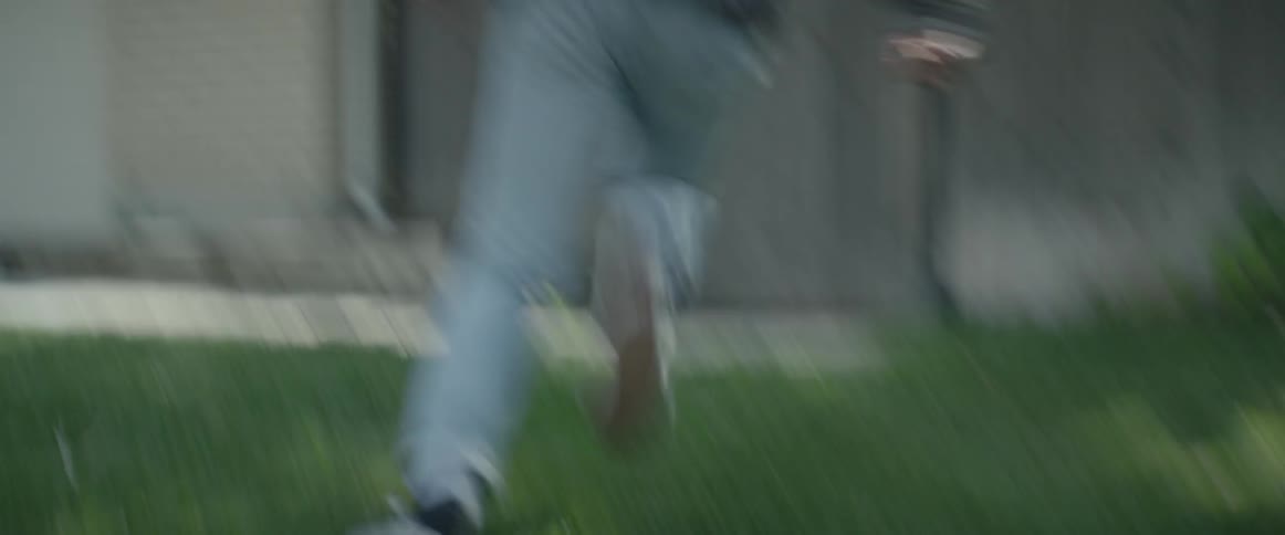 A man runs through a front yard and through a gate