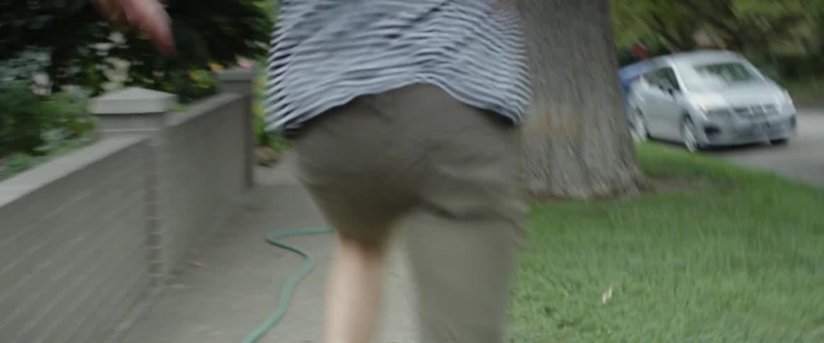 A man runs down a neighborhood sidewalk
