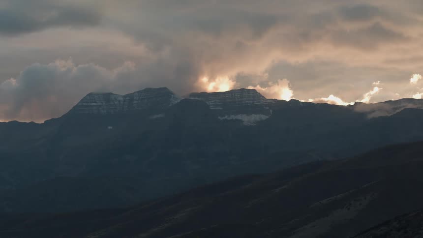 Sun shines through clouds over the mountains