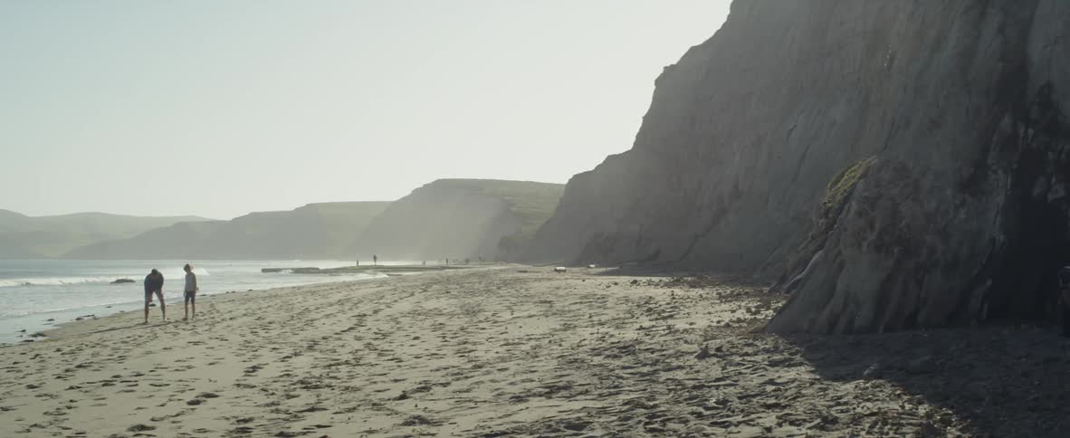 The people stand together by the water on the beach